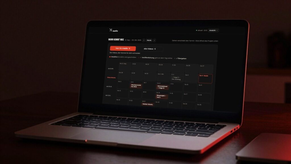 Laptop auf einem dunklen Schreibtisch, auf dem Bildschirm der Kalender des YA-media-Kundenportals mit Beispielprojekten